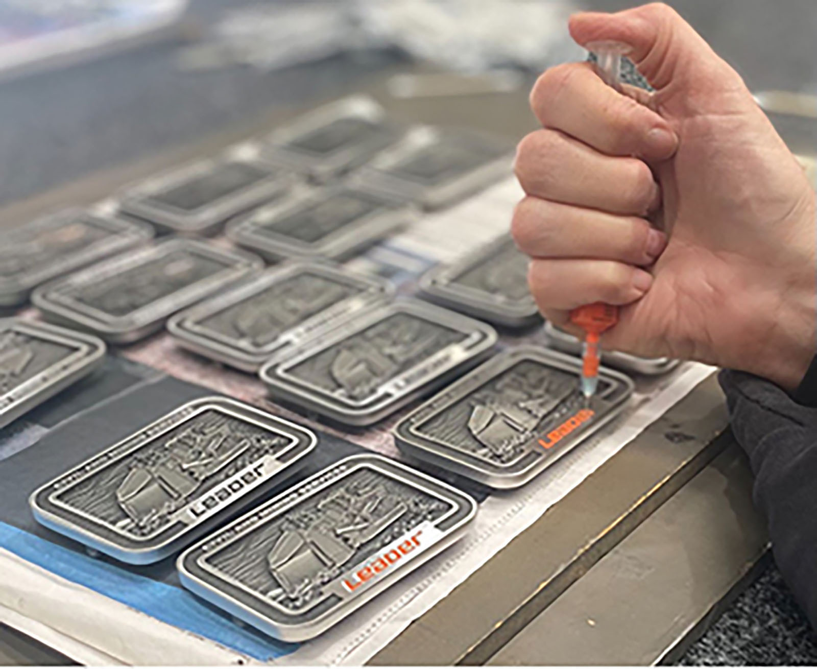 Hand finishing and assembly work on custom pewter belt buckle components before final presentation