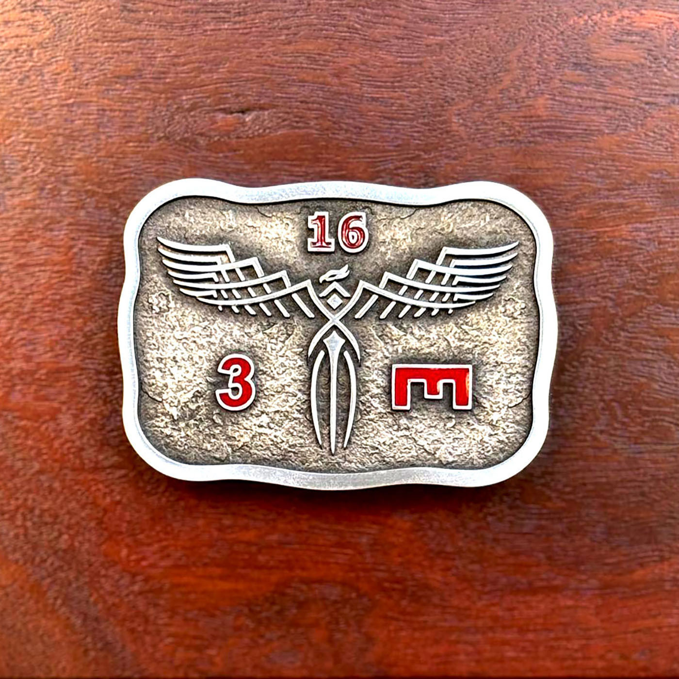 Military commemorative belt buckle featuring phoenix-inspired insignia artwork