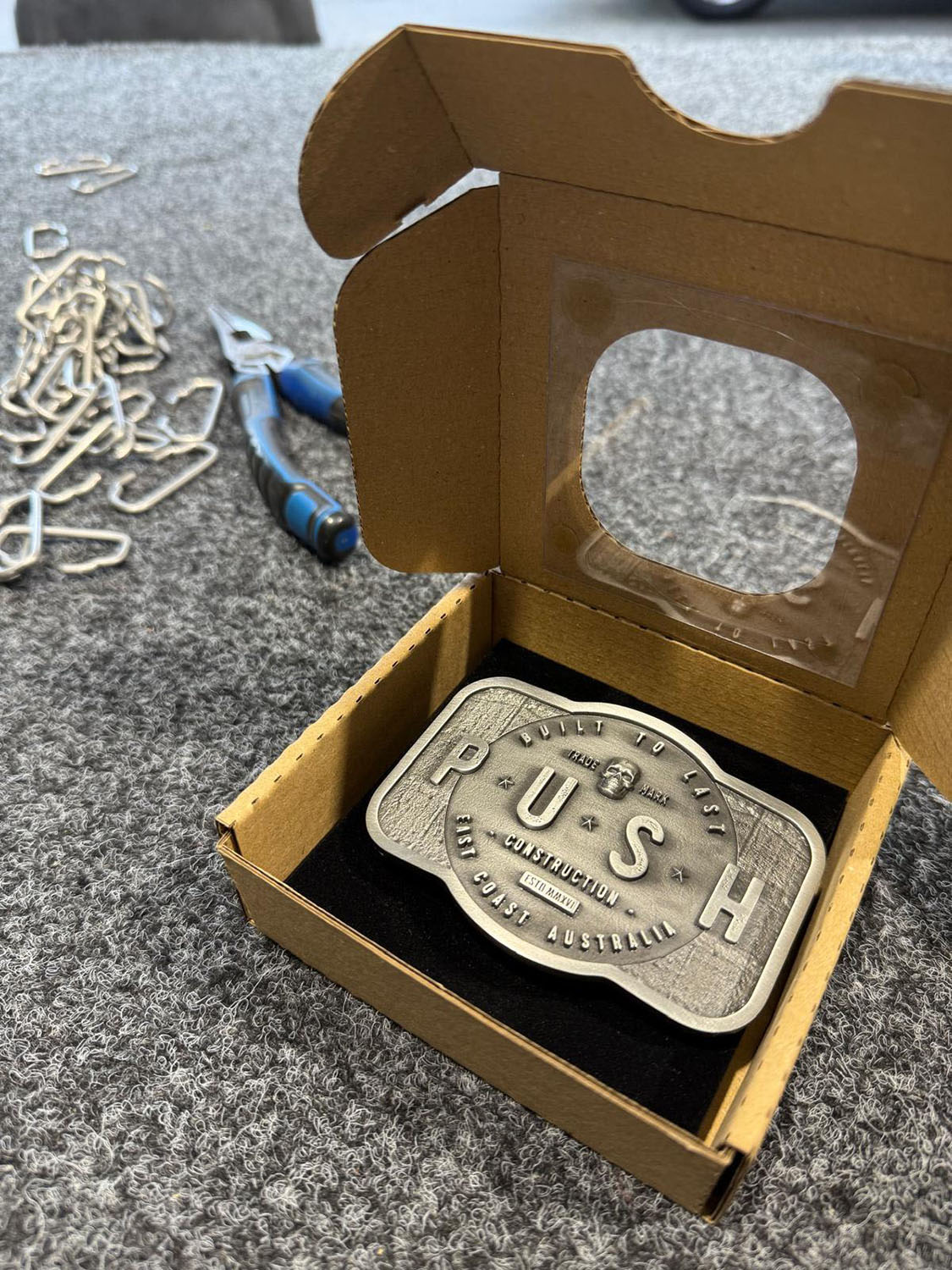 Custom pewter belt buckle packaged for presentation and team recognition