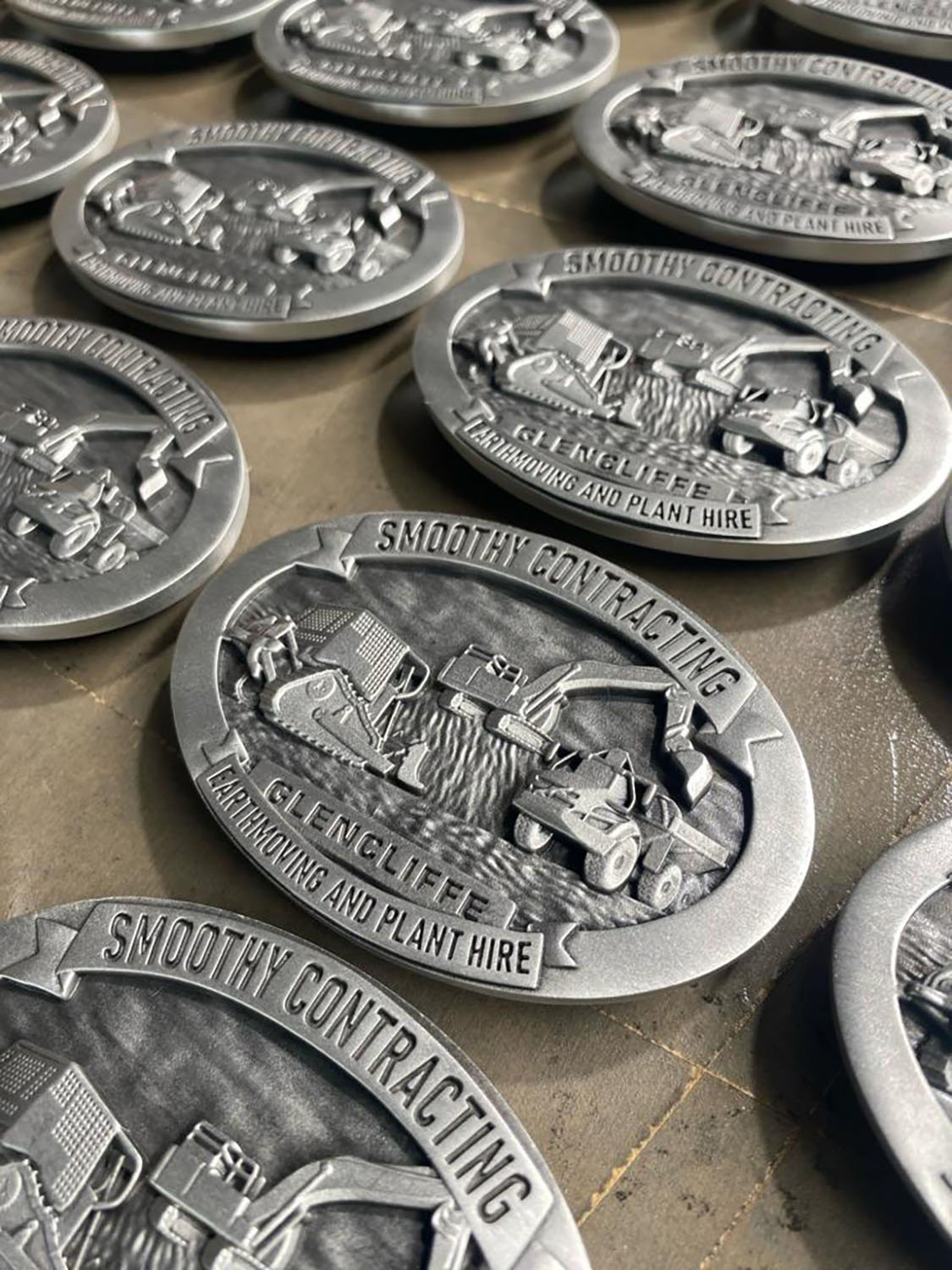 Smoothy Contracting commemorative mining belt buckles photographed during production
