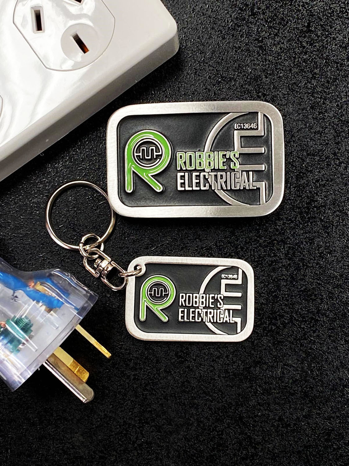 Custom branded pewter belt buckle and matching keyring accessory for electrical trade business branding