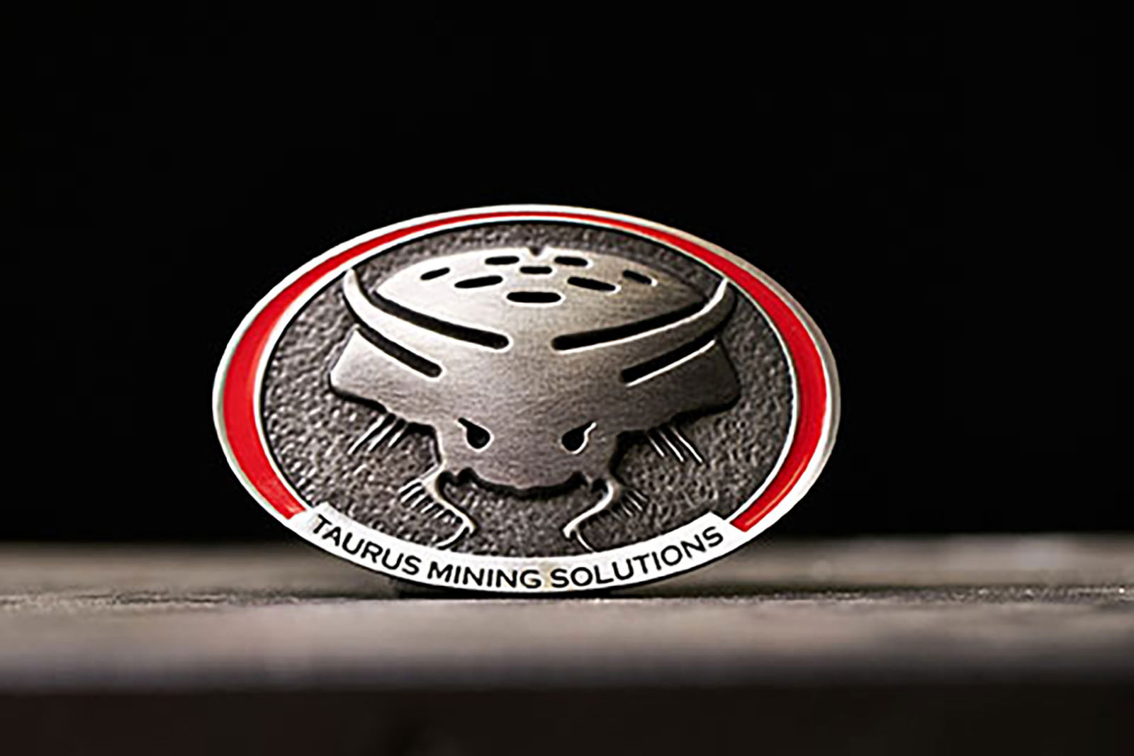 Taurus Mining Solutions custom pewter belt buckle with red enamel detail