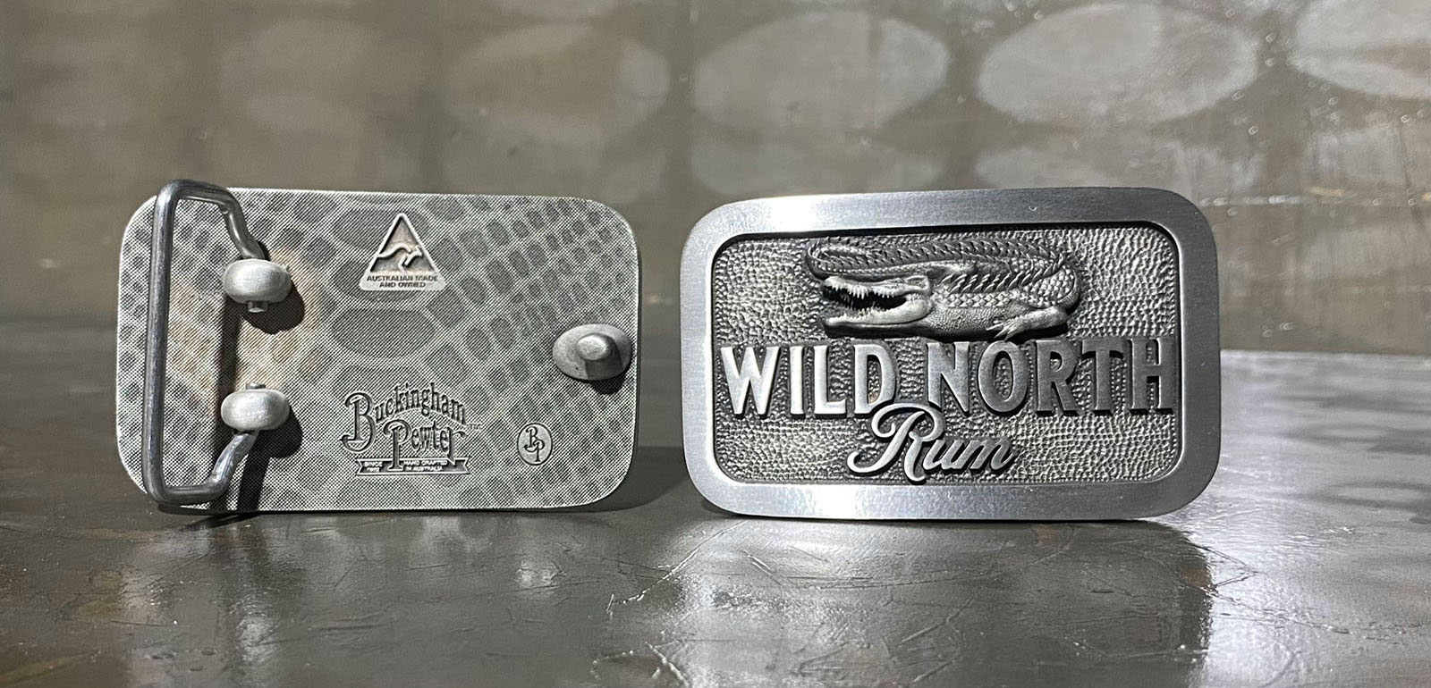 Wild North Rum branded custom pewter belt buckle photographed front and rear