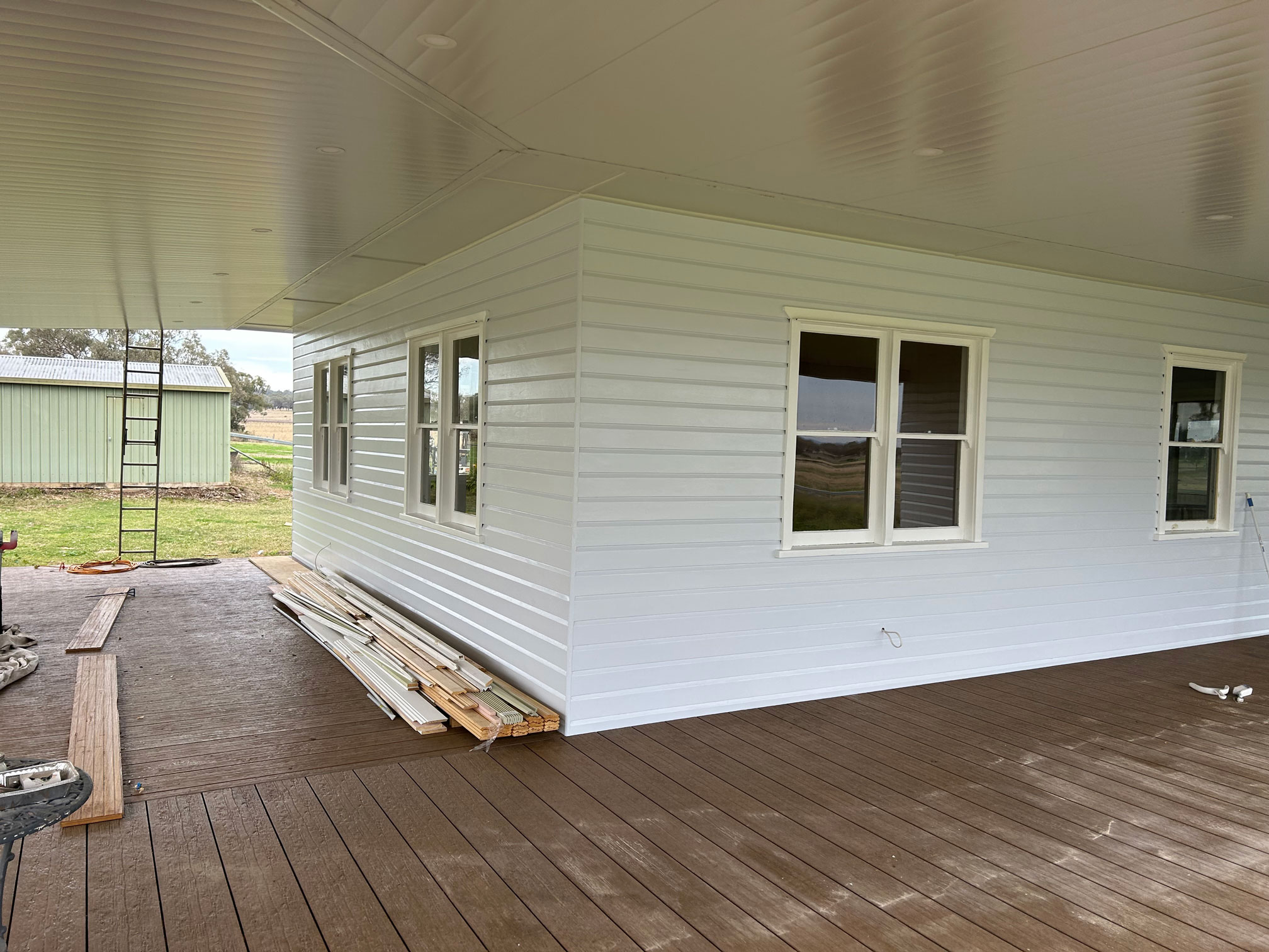Outside veranda area on a weatherboard home being painted.