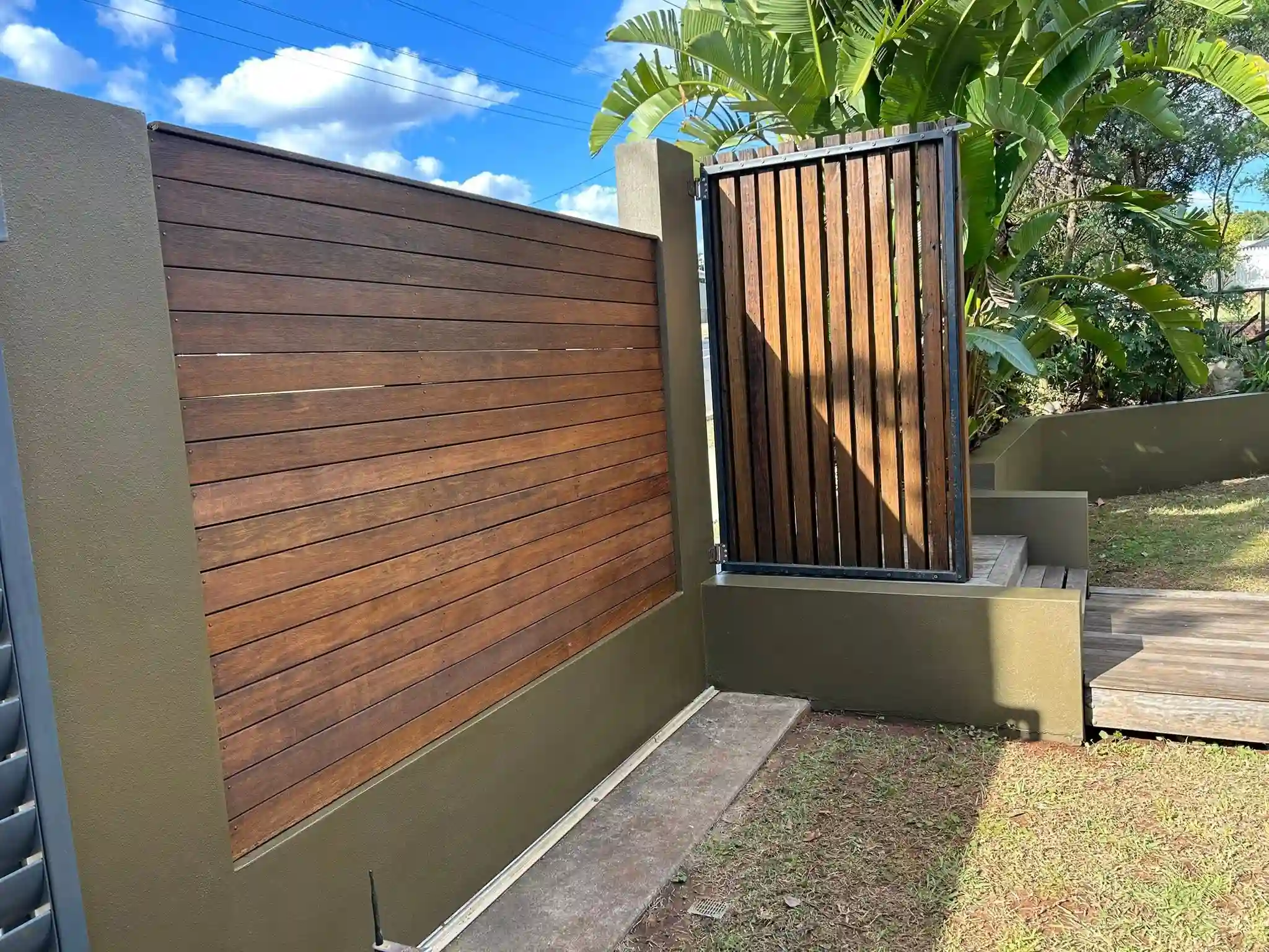 Recently stained fence and painted edging of a front fence and entryway