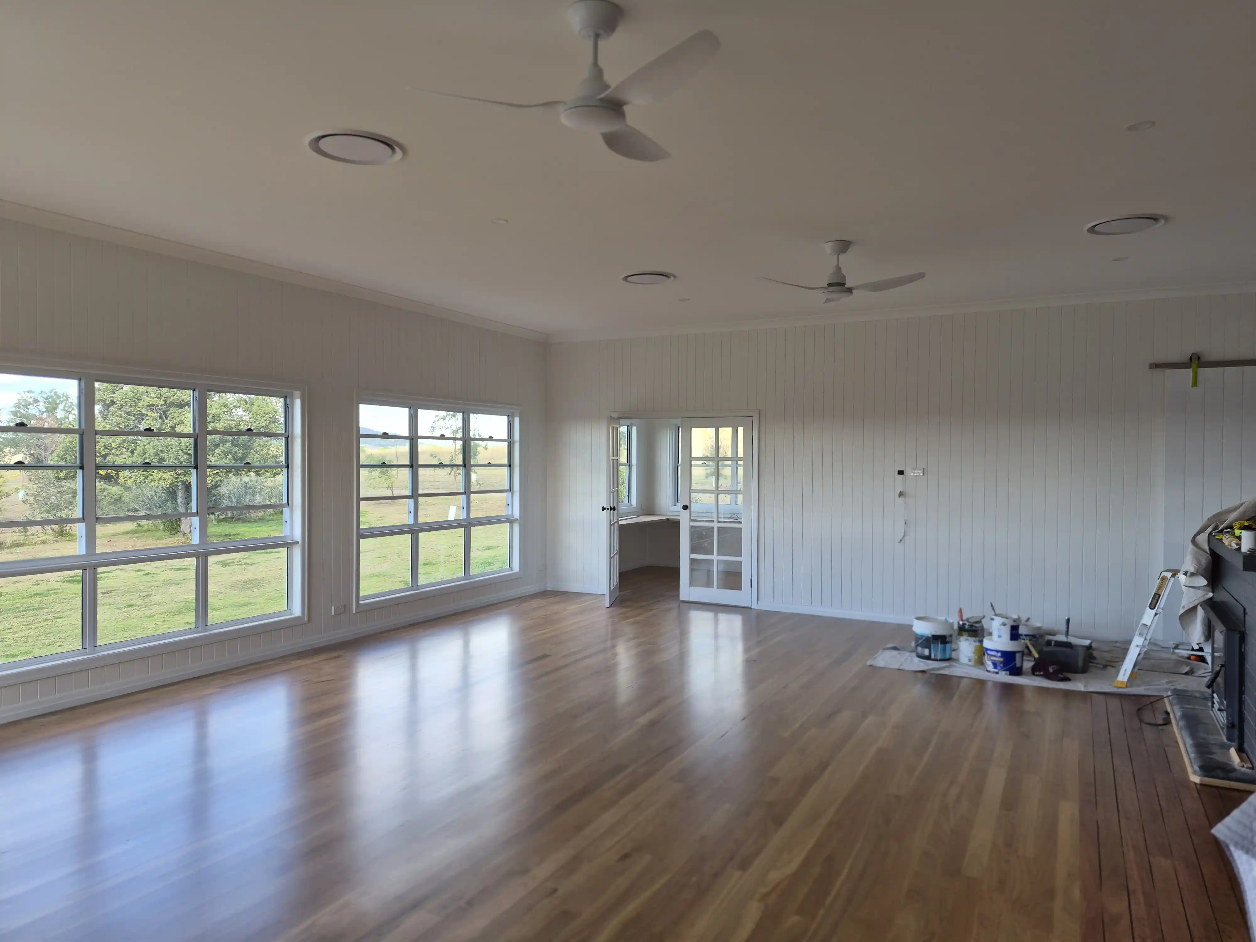 Freshly painted living room in a colonial styled home with v-board paneling.