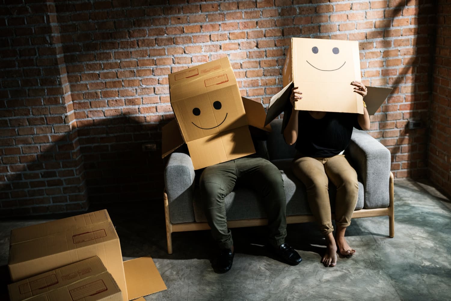 Two people with boxes on their heads with smiley faces