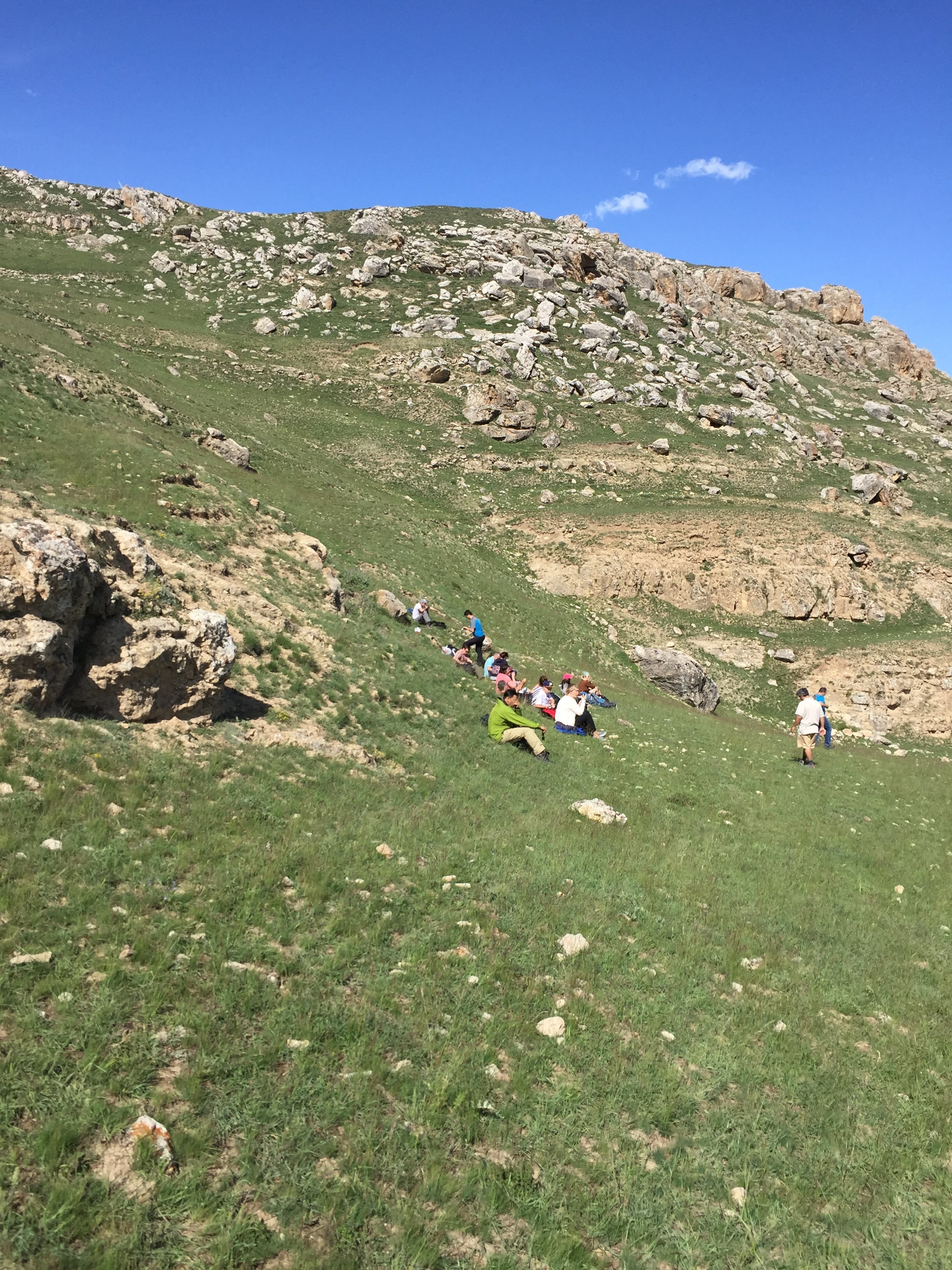 The founder resting mid-walk on a green mountain slope, Caucasus highlands, 2016.