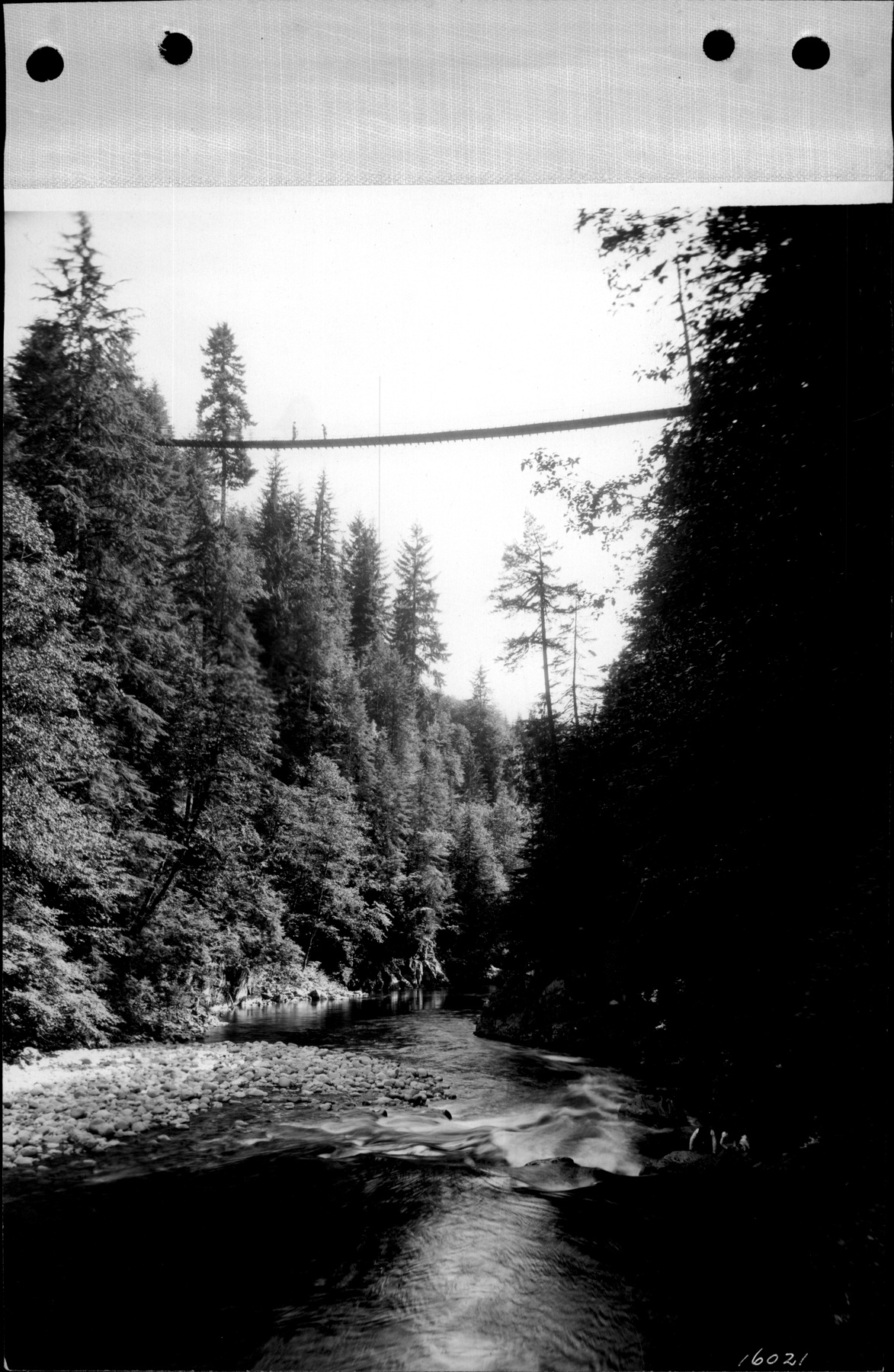 Visitors crossing the Capilano suspension bridge over the canyon, North Vancouver, around 1920