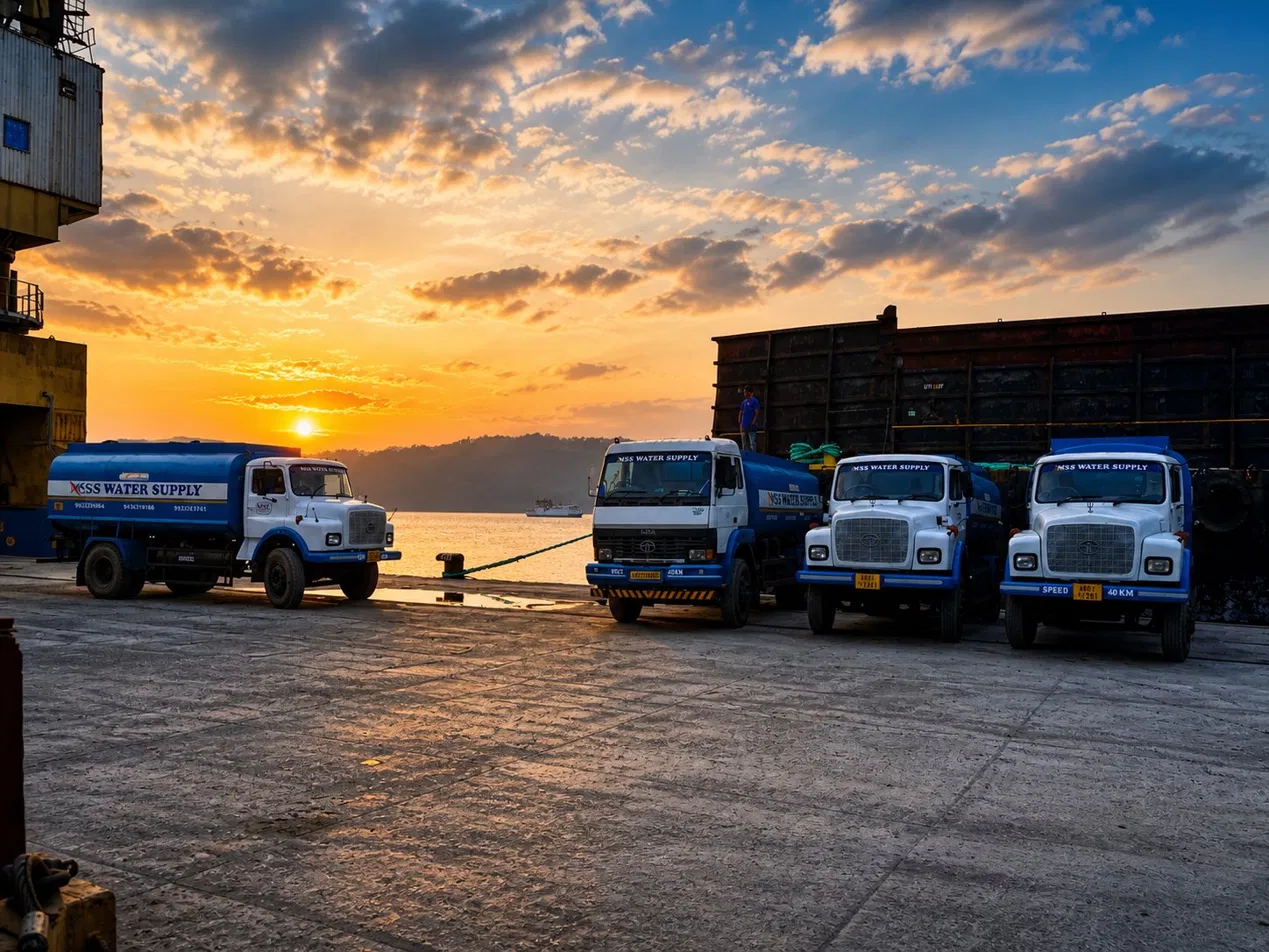 Water supply trucks servicing vessels at Port Blair harbour during sunset