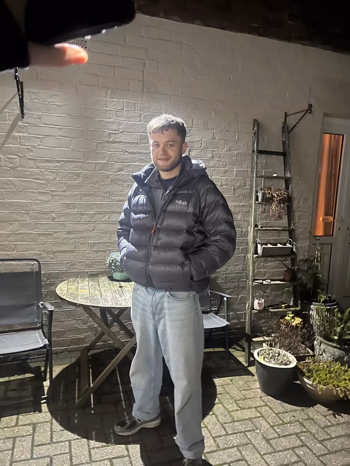 A picture of Oliver Taylor against a garden wall.