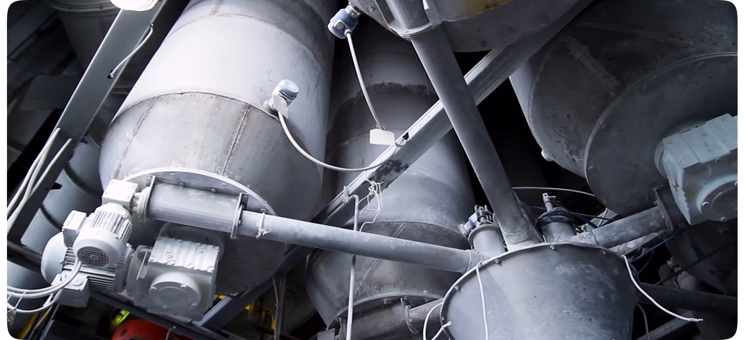 Metal industrial machinery with large cylindrical components and connected pipes in a factory setting.