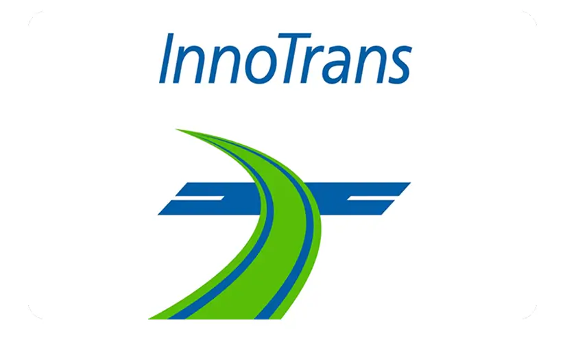 InnoTrans logo with green curved railway track and blue railway wings on white background.