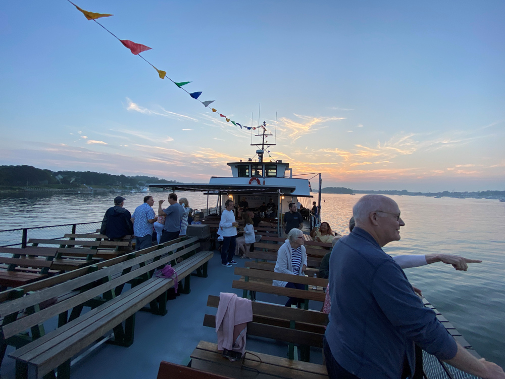 M/V Monhegan deck at golden hour with rainbow flag bunting and South Coast LGBTQ+ community on board