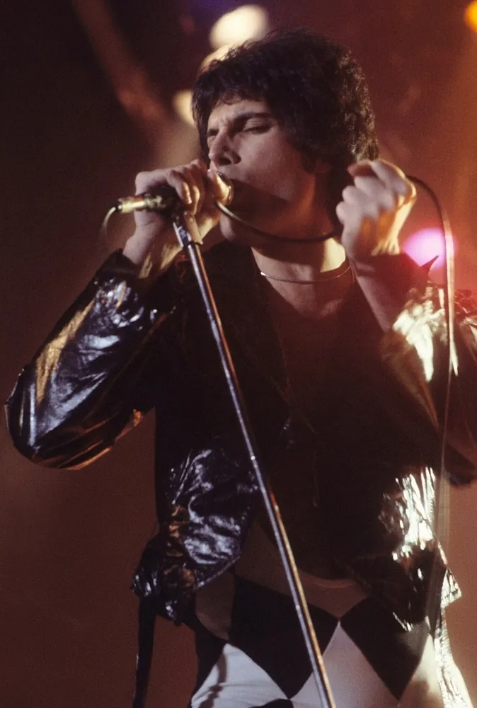 Freddie Mercury singing at a microphone on stage, New Haven, November 1977