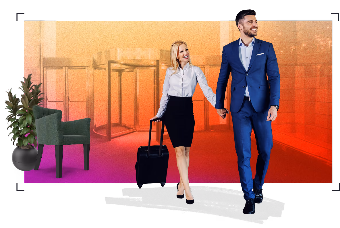 Man and woman walking through a hotel lobby with a suitcase