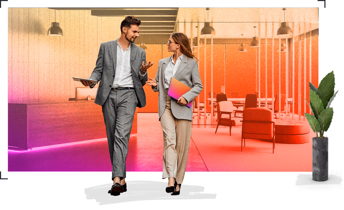 Two business professionals in suits discussing work while walking through a modern office