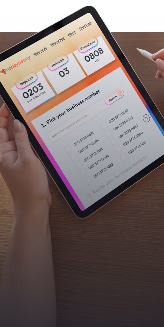 Person holding tablet showing a webpage to pick UK regional, national, or freephone business numbers.