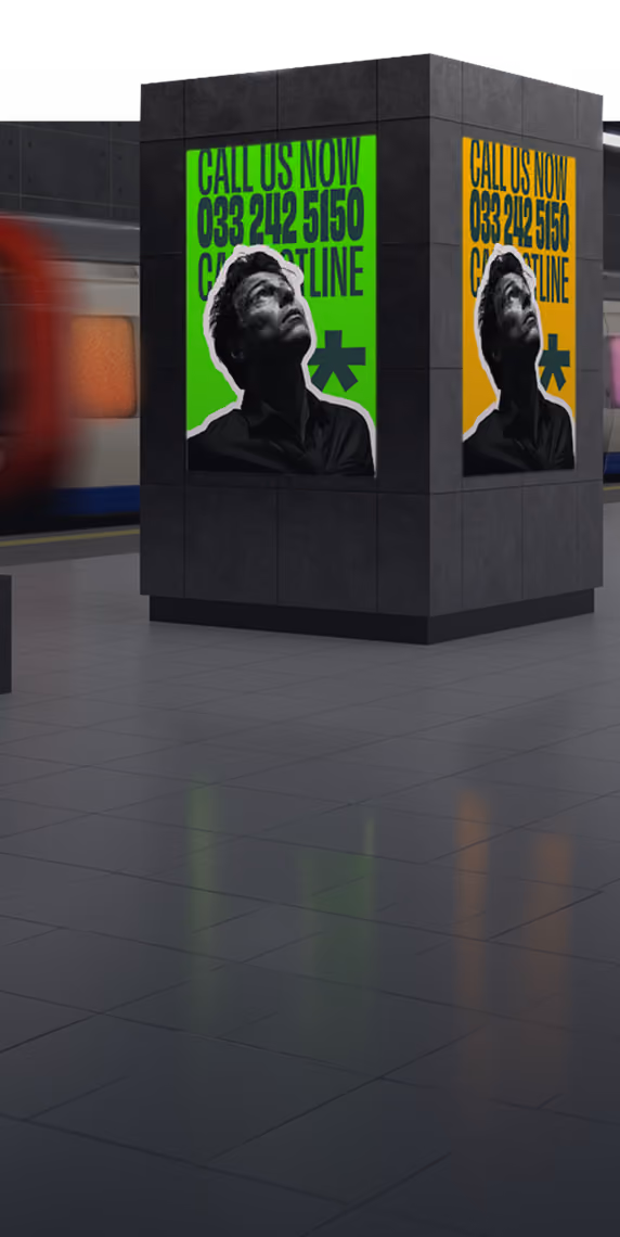 Subway station pillar with bright green and orange posters urging to call a helpline.