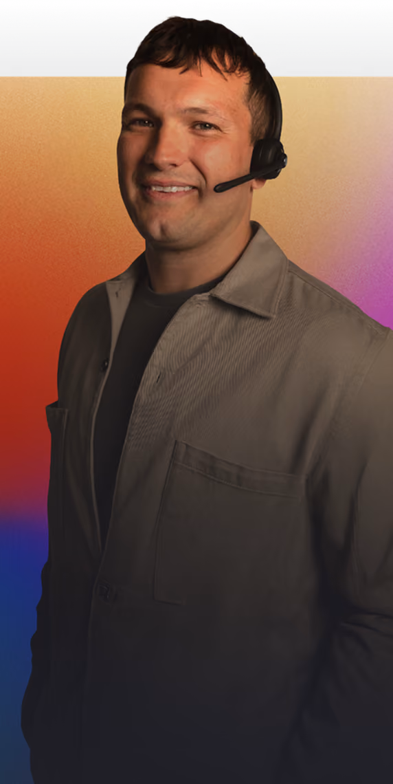 Smiling man wearing a headset and grey shirt against a vibrant multicolored background.