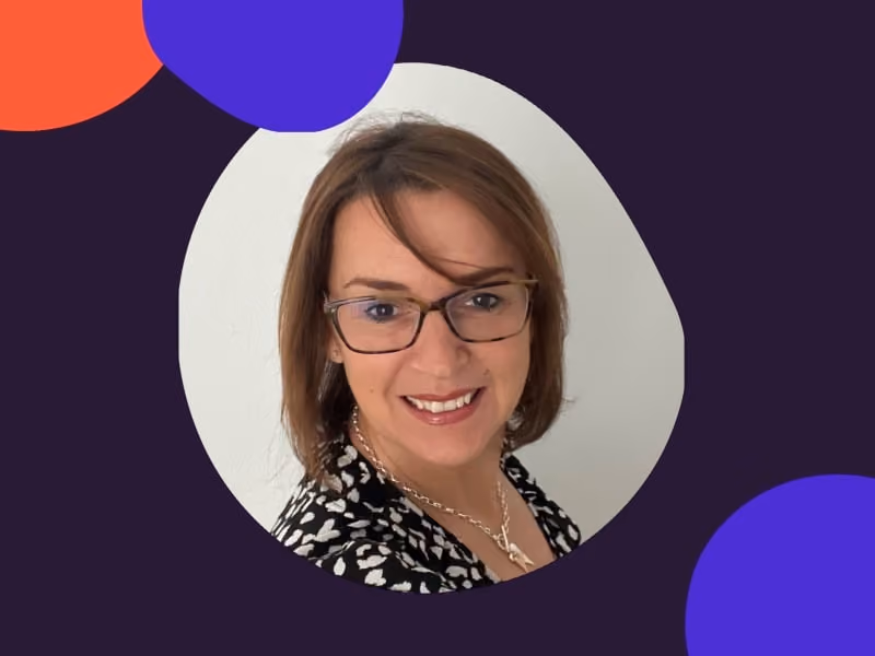 Smiling woman with glasses and short brown hair framed by colorful abstract shapes on a dark background.