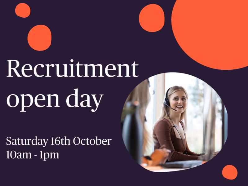 Smiling woman wearing headset works on computer during recruitment open day event.