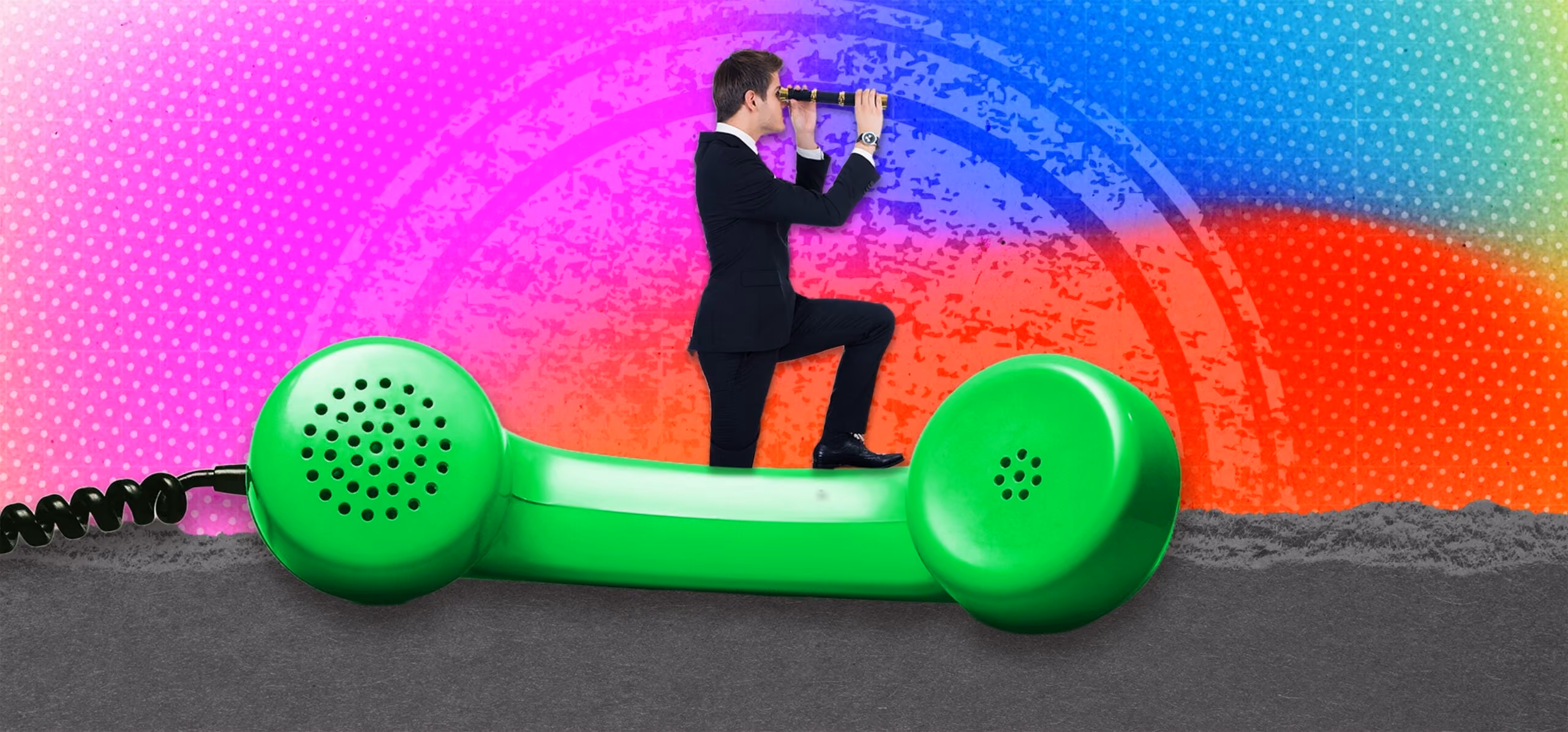 Man in suit kneeling on large green phone handset looking through binoculars against colorful background.