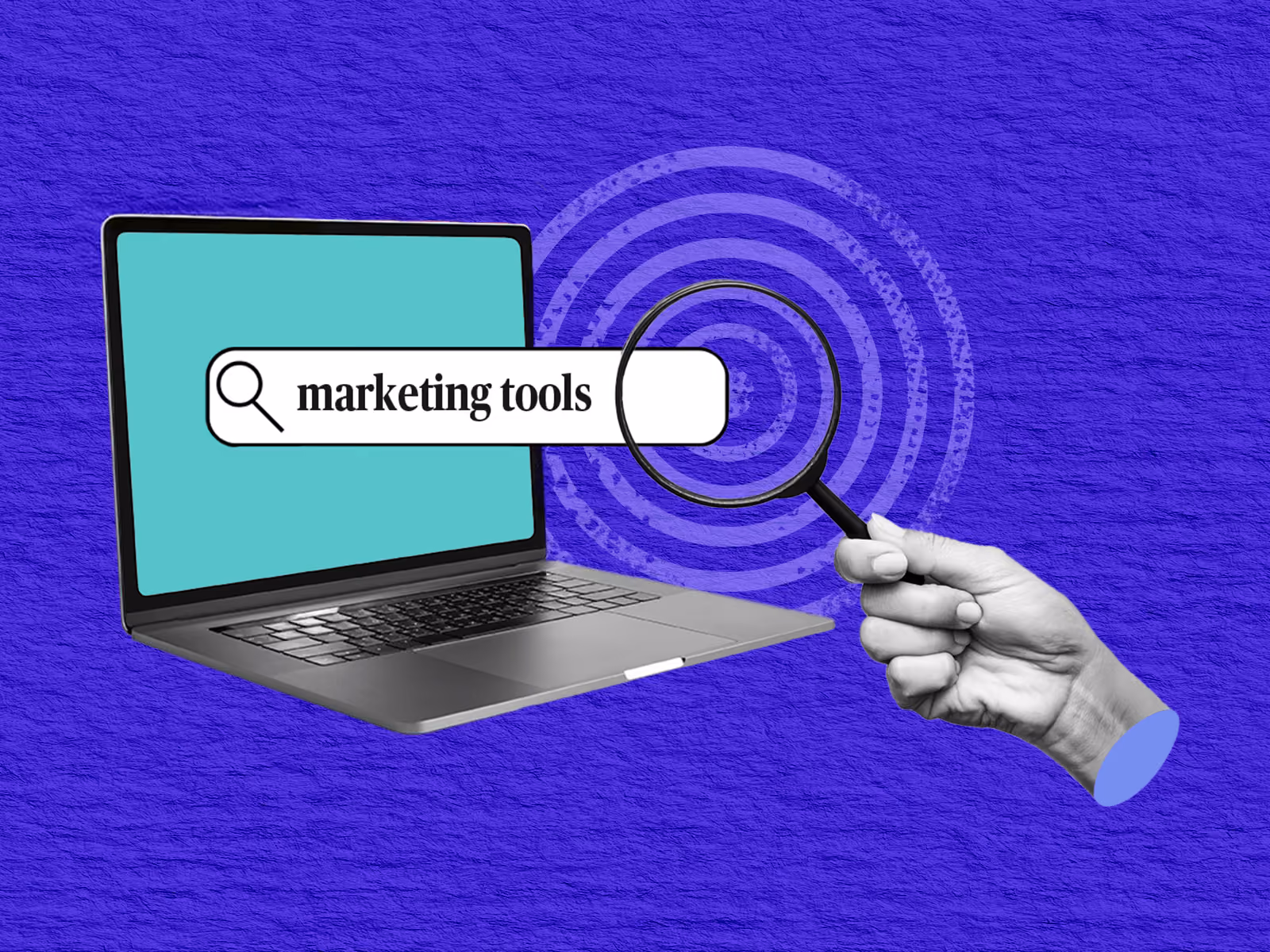 Laptop screen with search bar displaying 'marketing tools' and hand holding magnifying glass over a target.