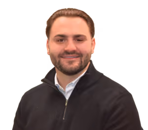 Smiling man with short brown hair, beard, and black quarter-zip sweater over a white shirt.