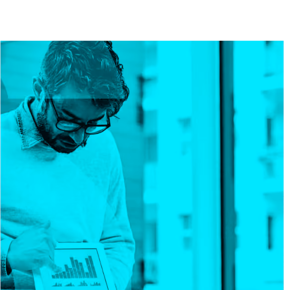 Man wearing glasses and sweater looking at a tablet displaying bar charts and graphs.