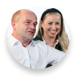 Smiling man and woman posing closely together in a circular frame on transparent background.