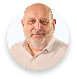 Portrait of a bald man with a beard wearing a light pink shirt against a white background.