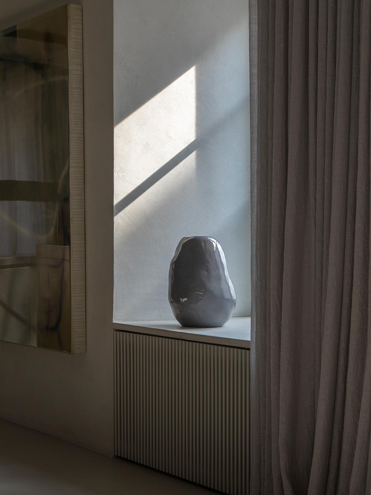 Sunlight on a wall, curtain and sculptural object in an interior