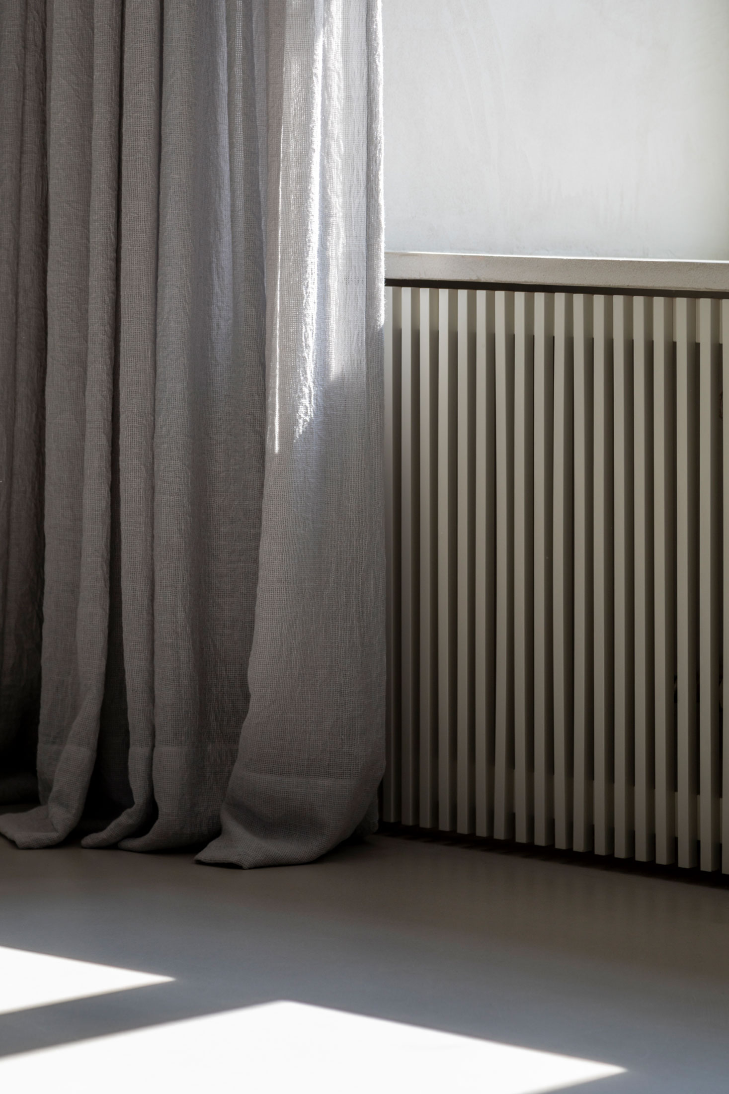 Curtain and ribbed radiator cover in side lighting