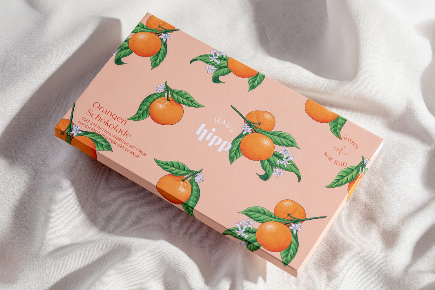 Apricot-coloured chocolate packaging with orange illustrations