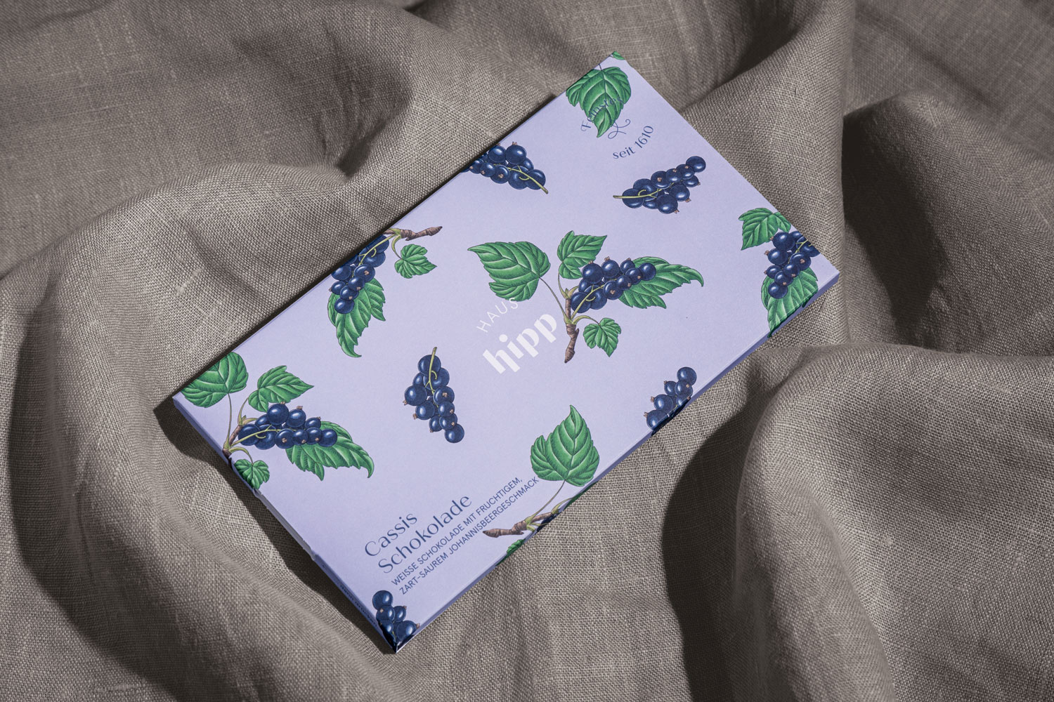 Lavender-coloured chocolate packaging with a berry motif on fabric