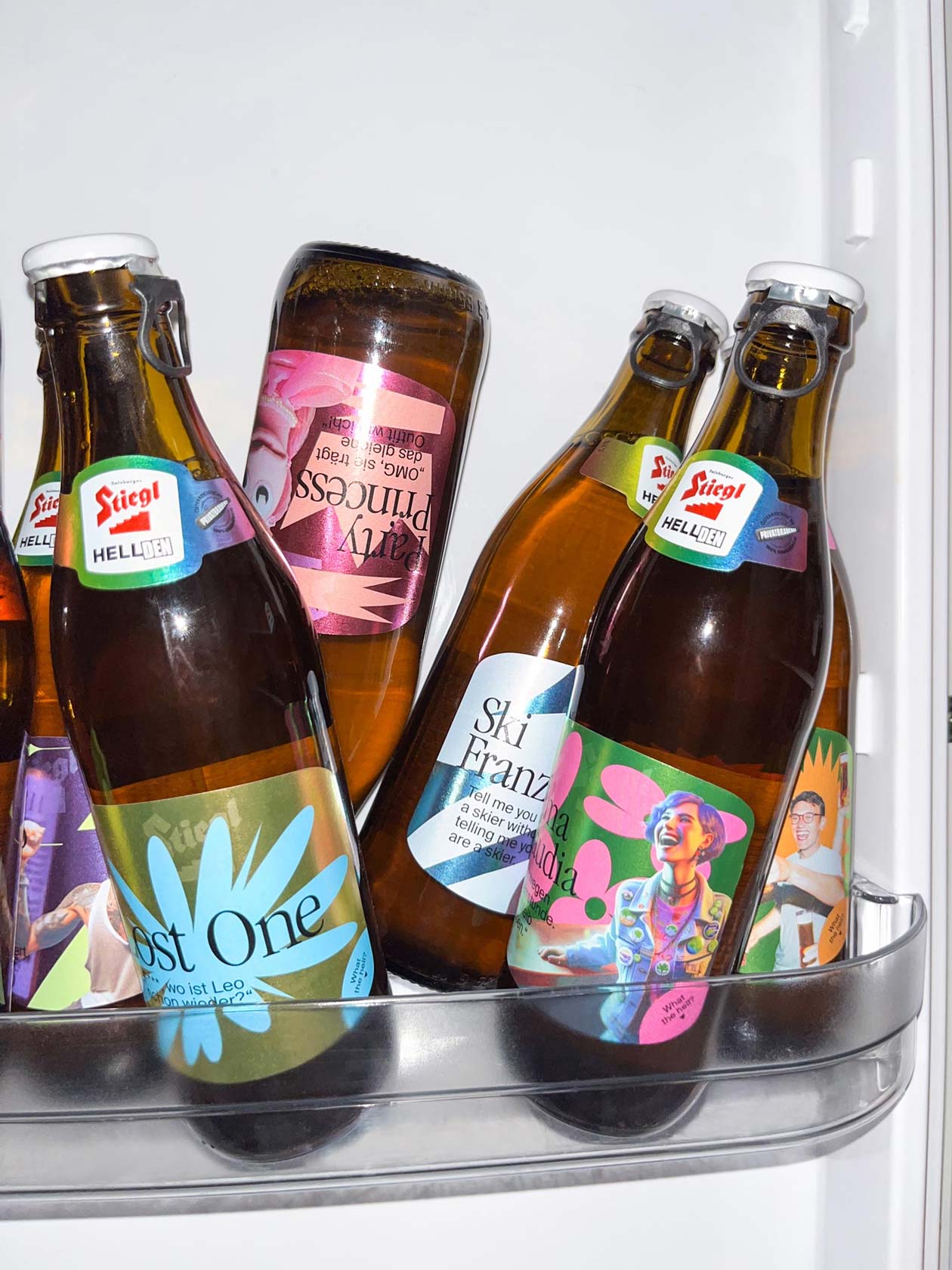 Stiegl beer bottles with colourful illustrated labels in a refrigerator door