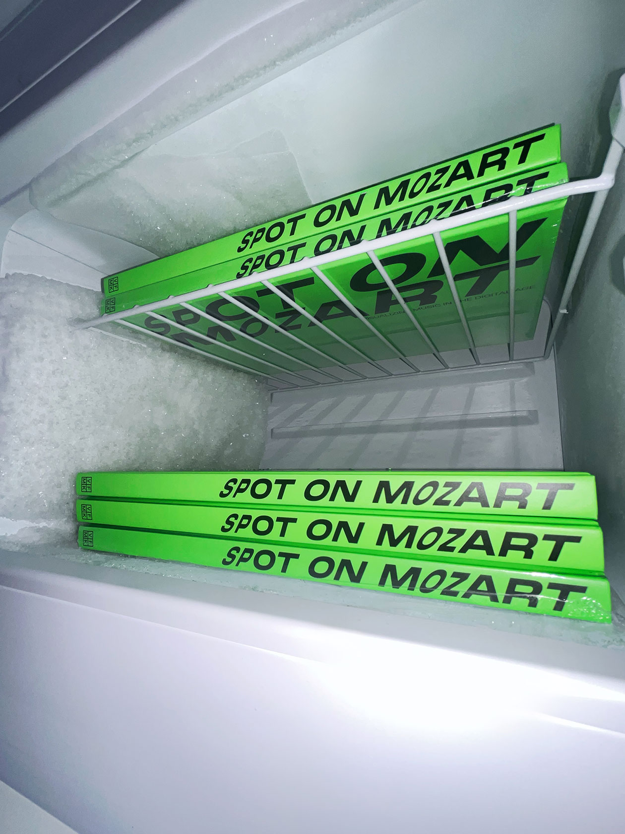 Neon-green Spot on Mozart books on a wire shelf