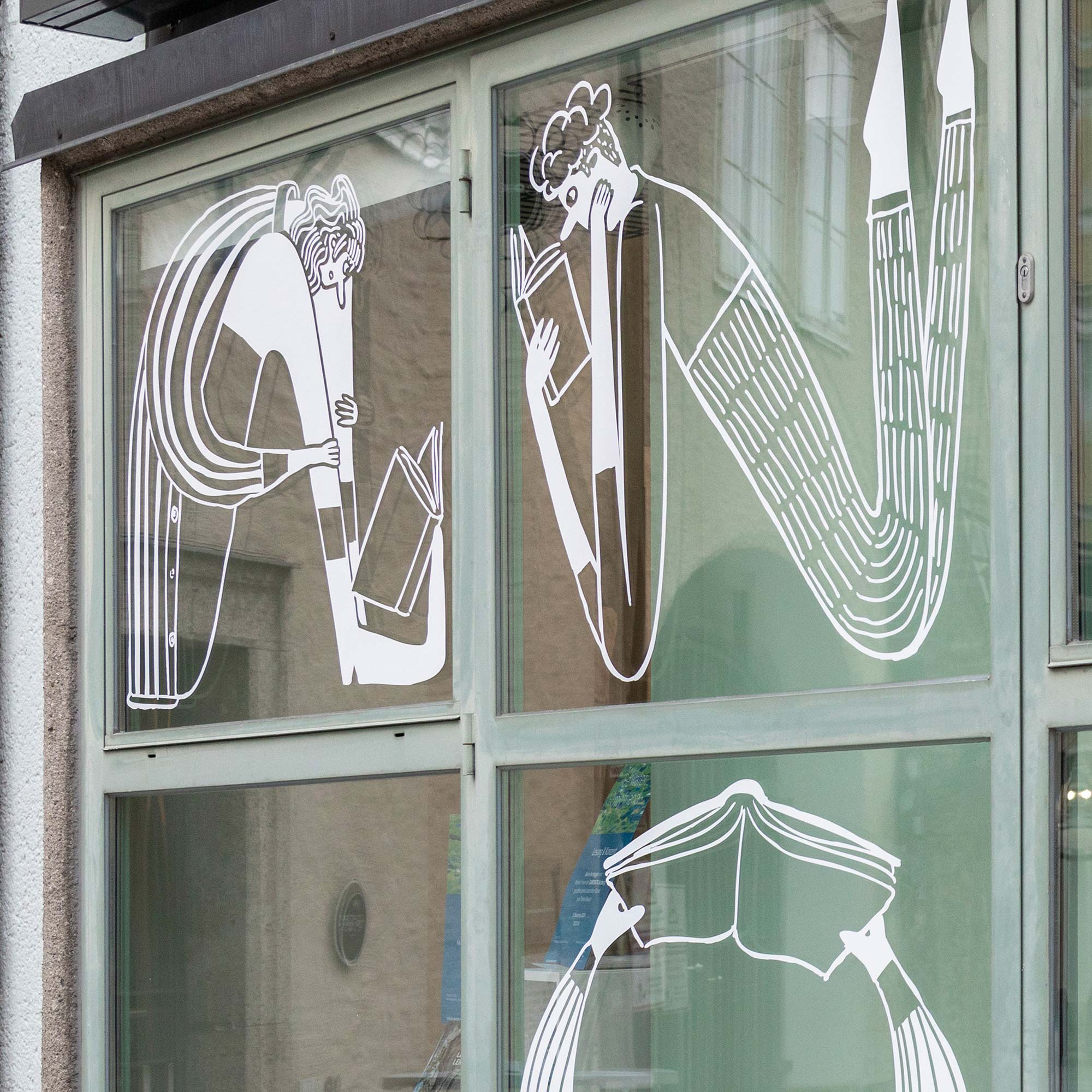 Anton Pustet Verlag shop window with white illustrations of reading figures