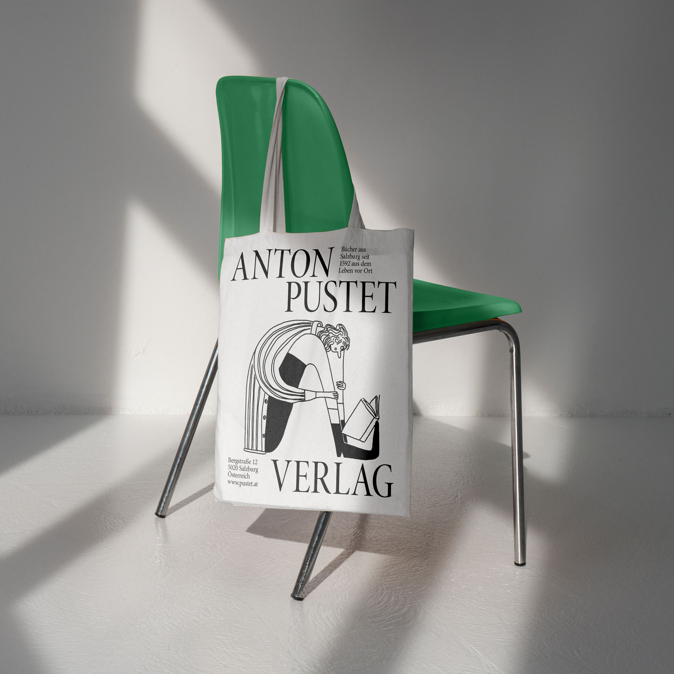 White Anton Pustet Verlag tote bag with a reading figure on a green chair