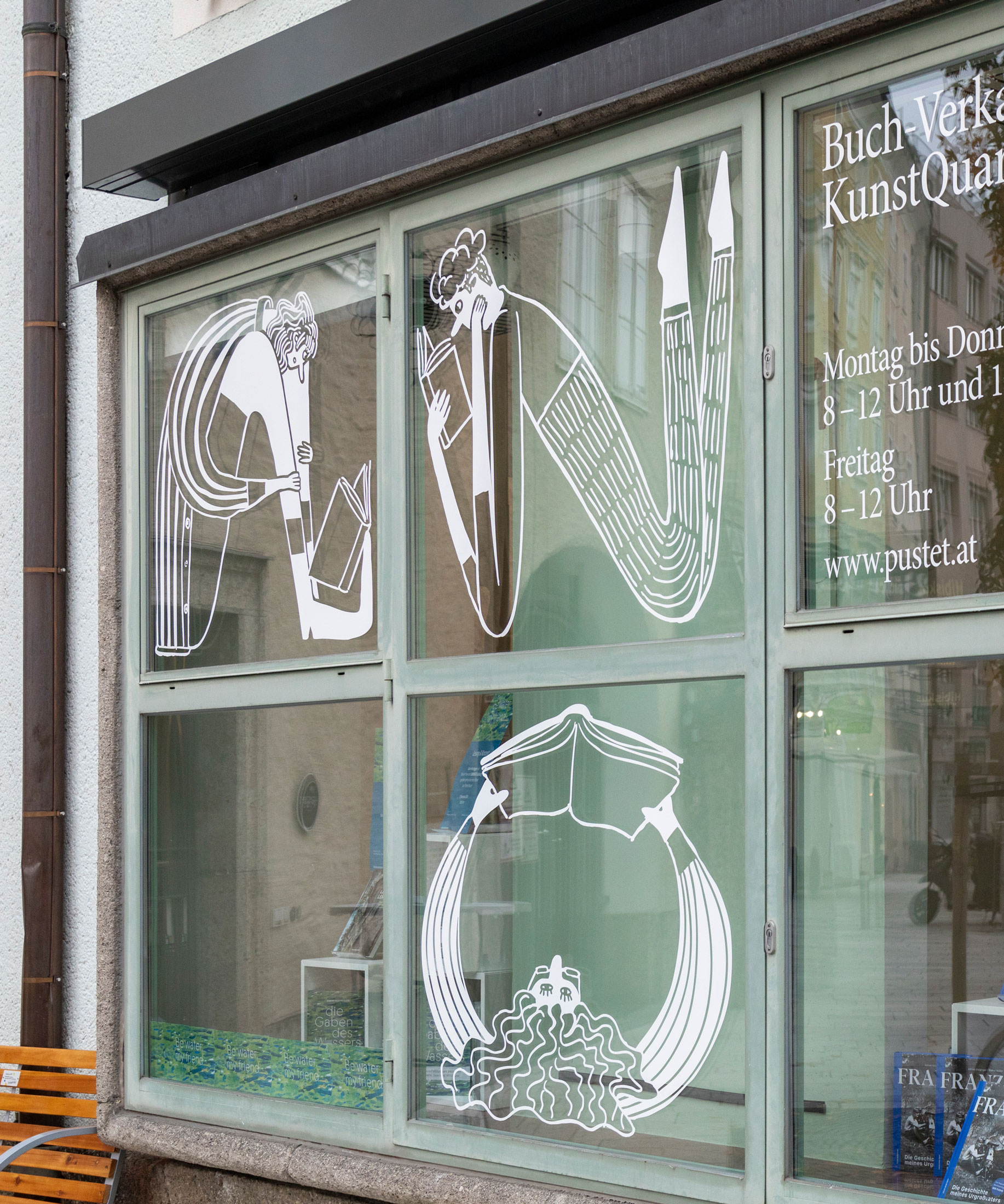 White character illustrations on the windows of Anton Pustet Verlag