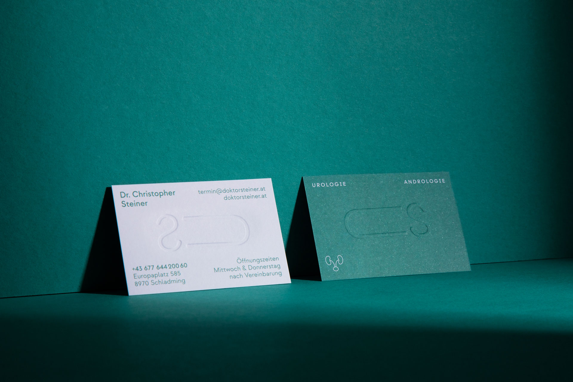 Front and back of a white and green business card