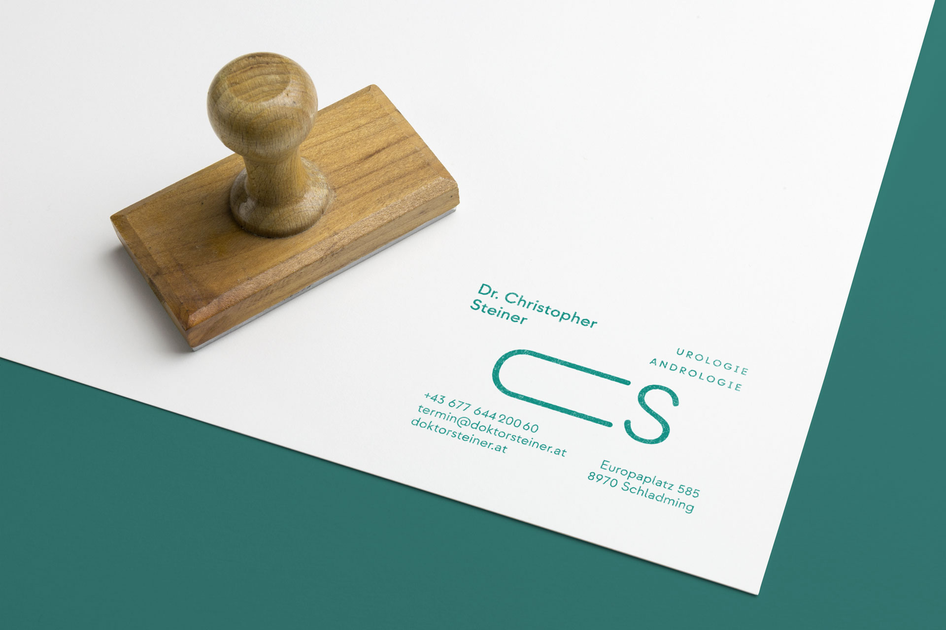 Wooden stamp on white stationery with a green CS logo