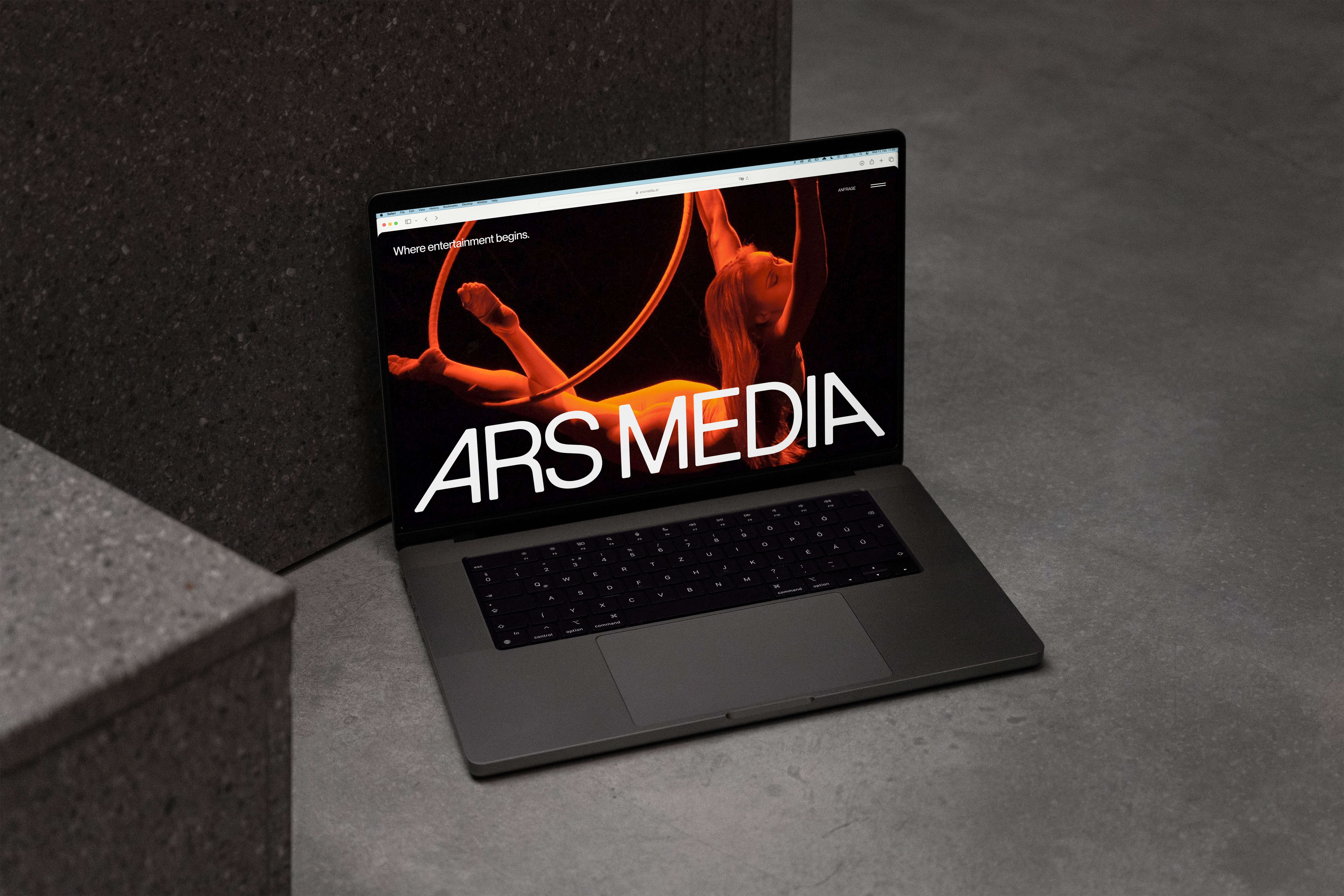 Ars Media website with a stage scene and large lettering on a laptop