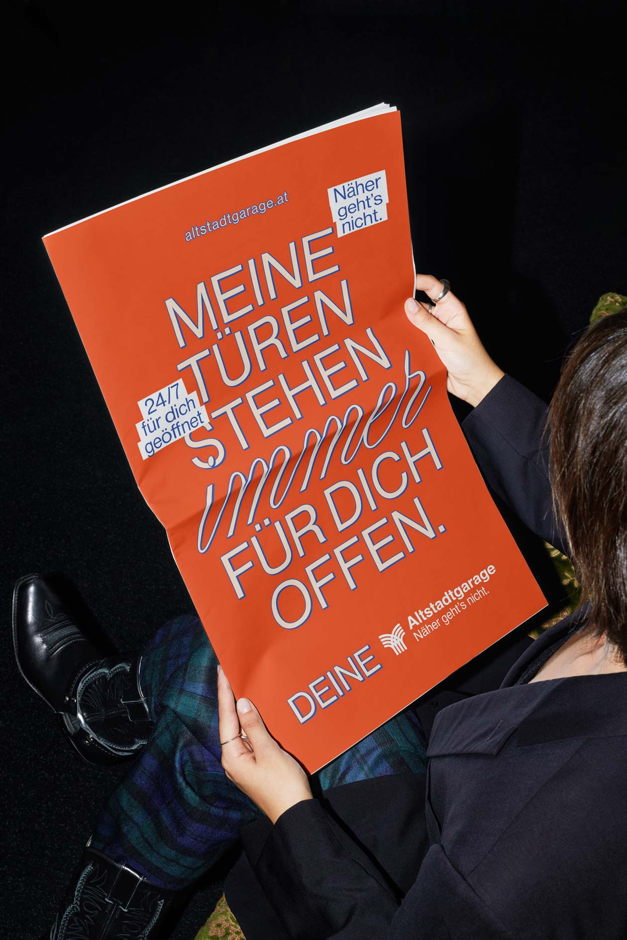 Person holding an orange poster reading Meine Türen stehen für dich offen