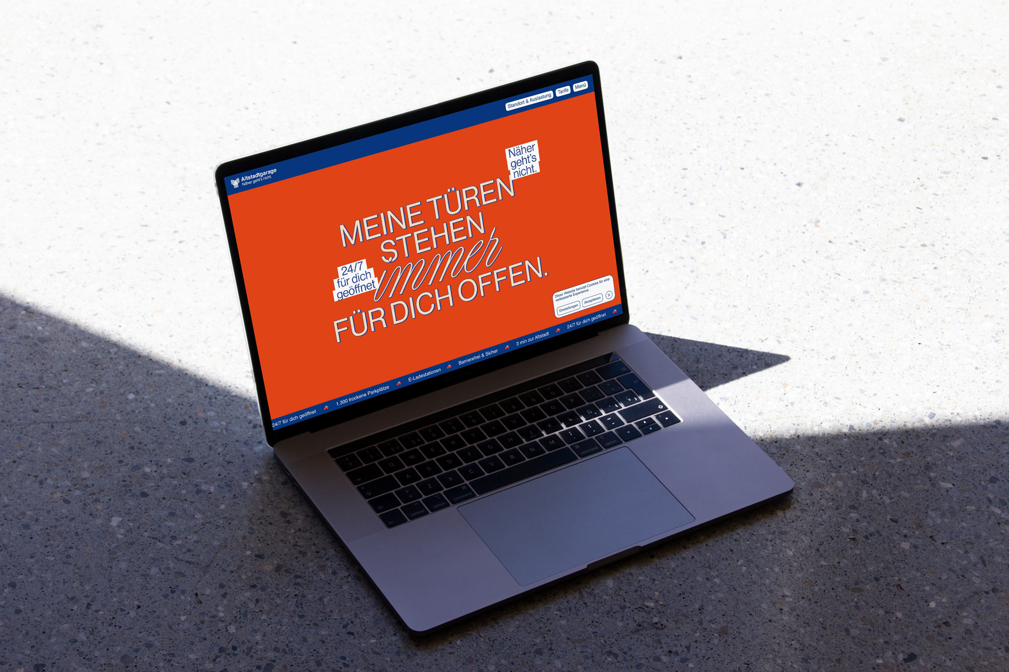 Altstadtgarage website with an orange campaign visual on a laptop