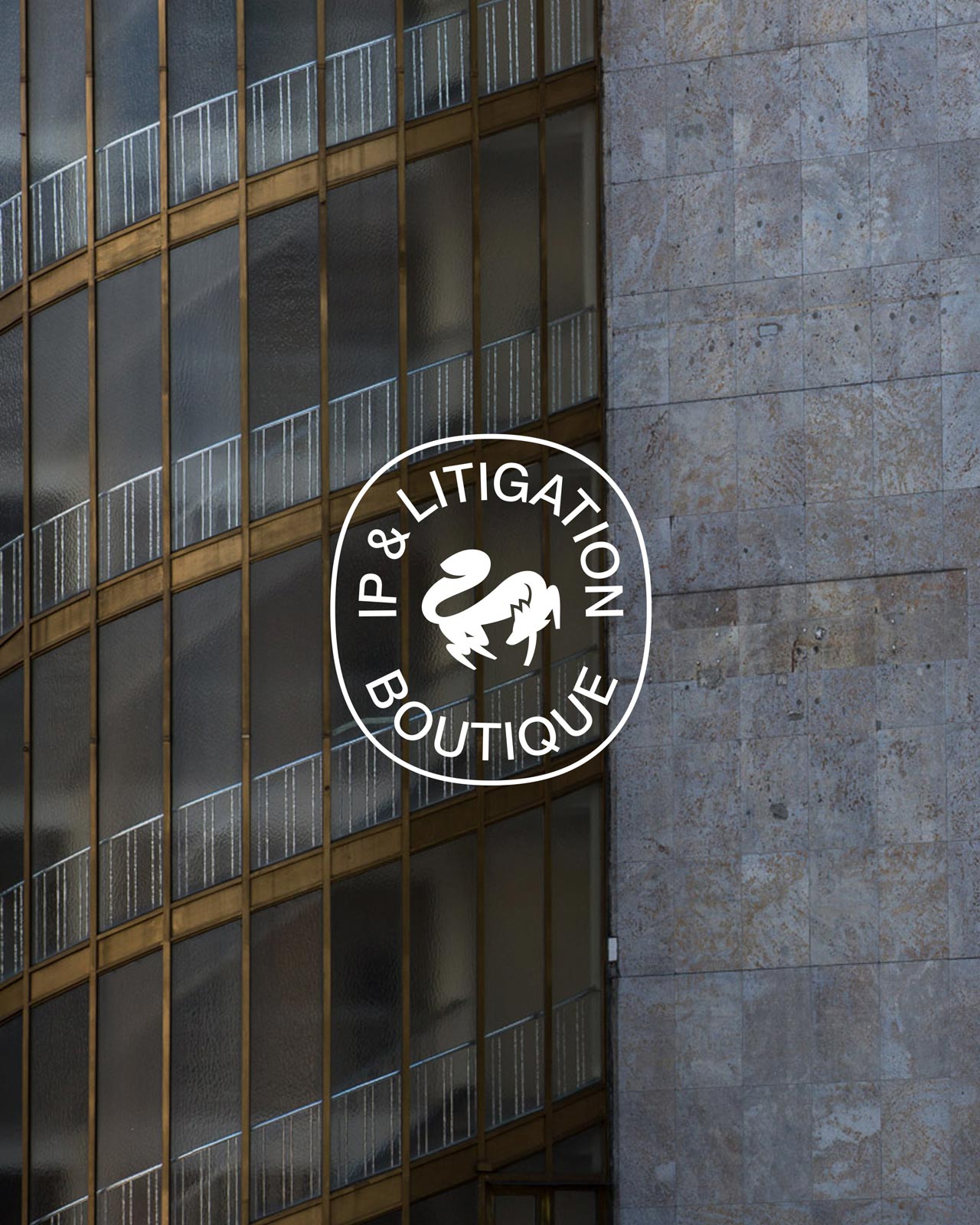 Circular lex.tm symbol on a glass facade