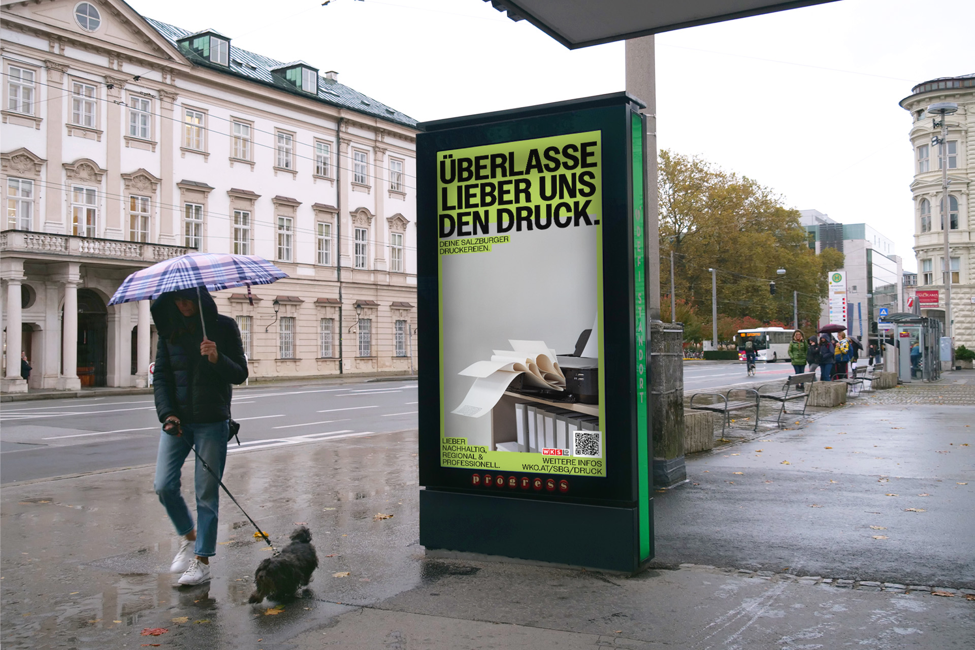 Beleuchtetes Druckerei-Kampagnenplakat an einer Bushaltestelle bei Regen