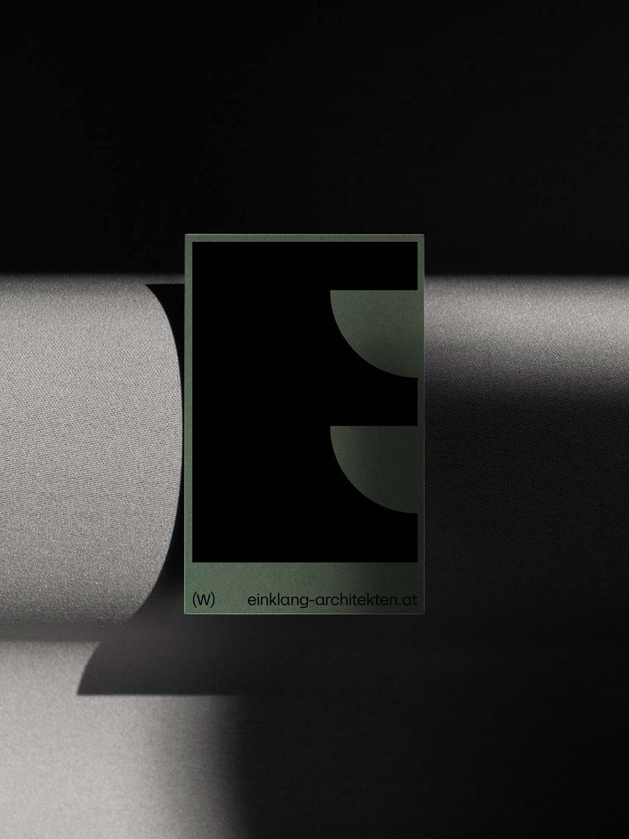 Dark-green Einklang poster with a large black geometric symbol