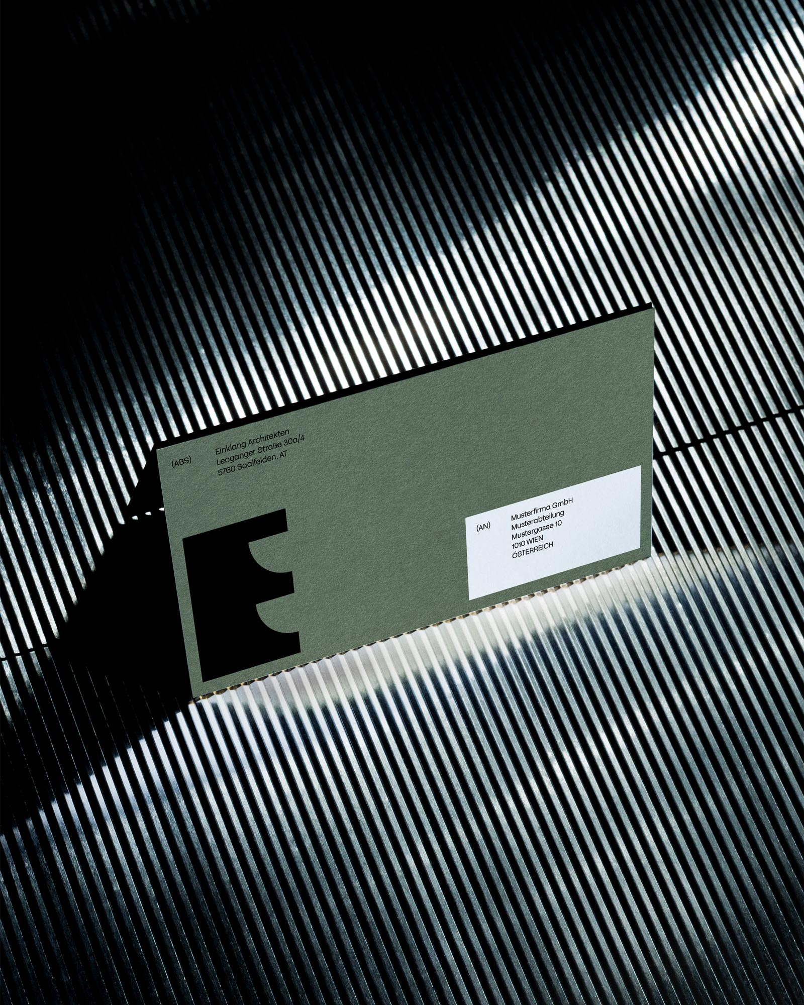 Green Einklang business card with a black symbol on a ribbed surface